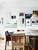 Different chairs at the dining table in front of the picture wall