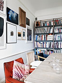 Different chairs at the dining table in front of the picture wall