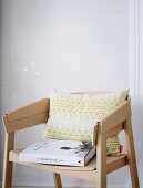 A patterned cushion and a recipe book on modern chair