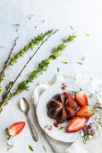 Gestürzter Schokoladenpudding dekoriert mit Erdbeeren und Erdbeerpulver