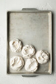 Baked meringues on a baking tray (seen from above)