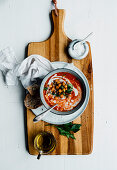 Tomatensuppe mit Kichererbsen auf Holzschneidebrett