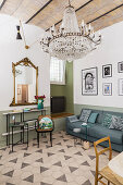 Console table, gilt-framed mirror, sofa and chandelier in living room