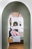 View of double bed through arched doorway