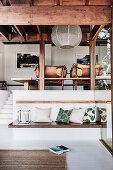 Two-part lounge in the split-level house: built-in bench with cushions below, vintage leather armchair above