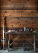 An rustikaler Holzwand angelehnte Skier neben Buffet mit Salami, Wein und Brot