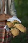 Frau hält Baguette mit Kräuterfüllung