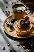 Cupcake with caramel cream and blackberry, served with coffee