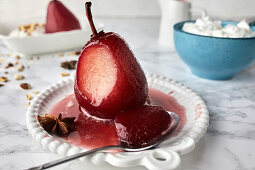 Pears poached in red wine sauce with spices served with mascarpone and cream