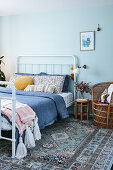 White bed in pale blue bedroom