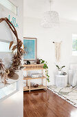 Türkranz aus getrockneten Pflanzen, Blick auf Rattanregal in weißem Wohnzimmer