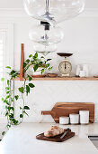 L-shaped kitchen counter below houseplants and vintage scales on shelf