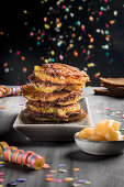 A stack of potato fritters with apple sauce and carnival decorations