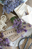 Lavendelblütenstrauß in Spitztüte, gefaltete Briefumschläge und gestempelte Papierschilder