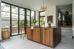 Elegant island counter with wooden front next to terrace doors