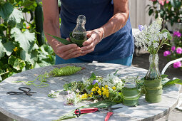 Wiesenblumen in hübsch verkleideten Flaschen