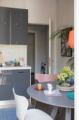 Round dining table in small kitchen-dining room with grey cabinets