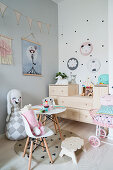 Soft toy's tea party in girl's bedroom in pastel shades