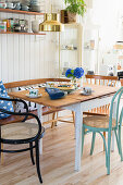 Spoke-back bench and various chairs around table in kitchen-dining room