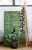 Verschiedene Wohnaccessoires: Wandbild und Sitzpouf in Grün, Deko-Vogel mit Käfig und Holz-Kleiderständer