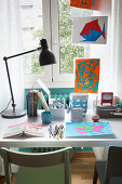 Desk next to window in child's bedroom decorated with children's pictures