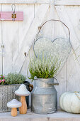 Autumnal arrangement of plants, mushroom ornaments and pumpkin