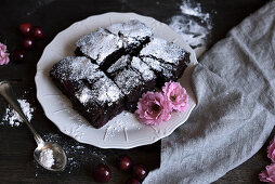 Chocolate cake with cherries and icing sugar