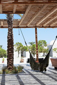 Hammock on terrace with thatched sun shade