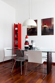 Narrow set of red shelves in corner and glass dining table