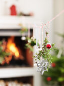 Christmas decorations hung from string in front of fireplace