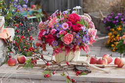 Autumn bouquet of roses, asters, stonecrop, rose hips, and spindle
