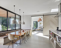 Dining table with shell chairs and corner bench in modern kitchen-dining room