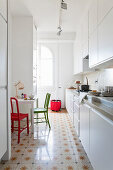 White kitchen counter in kitchen area separated by floor-to-ceiling partition shelves