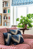Sofa with zigzag pattern and houseplant on side table in front of window
