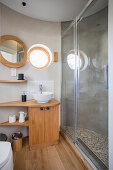 Badezimmer in rundem Anbau eines Tiny Houses mit Holz-Waschtisch und verglaster Dusche