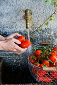 Tomaten am Brunnen waschen