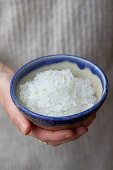 Hand hält Schale mit Gin Tonic Granita