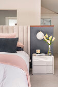 Half-height partition wall behind bed in pastel bedroom