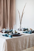 Pheasant feathers on table set in blue and natural shades