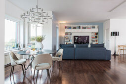 Interior divided into dining area by window and TV and lounge area in background