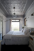 Double bed in bedroom with silver stucco ceiling