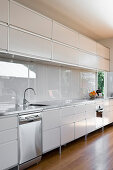 White kitchen counter with stainless steel trim and splashback