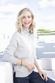 A blonde woman wearing a light-grey jumper