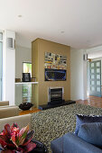 Armchairs, sofa and long-pile rug in front of modern fireplace in seating area