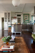 Offener Wohnraum im Vintagestil mit Holz-Couchtisch und Edelstahlküche im Hintergrund