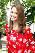 A young woman wearing a red floral-patterned Carmen blouse