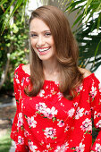 A young woman wearing a red floral-patterned Carmen blouse