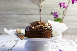 Chocolate cake with chocolate sauce pouring on top of it