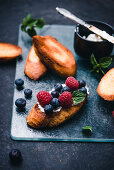 Toasted baguette slices with almond cream cheese, berries and mint (vegan)