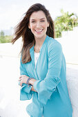 A young woman wearing a blue shirt blouse